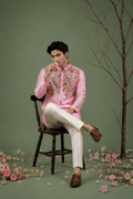  Man sitting wearing pink floral embroidered kurta - styled shot